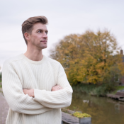 kleurenfoto van presentator Winfried Baijens voor huizen in Groningen met armen over elkaar