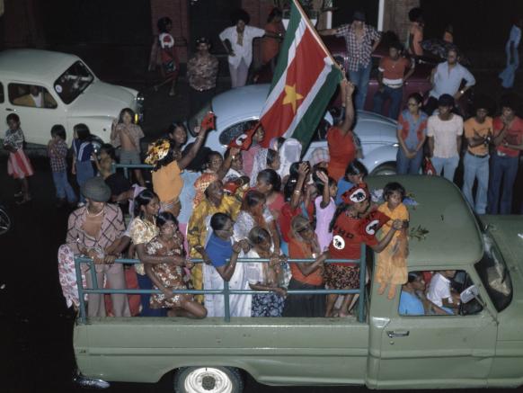kleurenfoto onafhankelijkheid vierende Surinamers achterin pickup truck 1975 