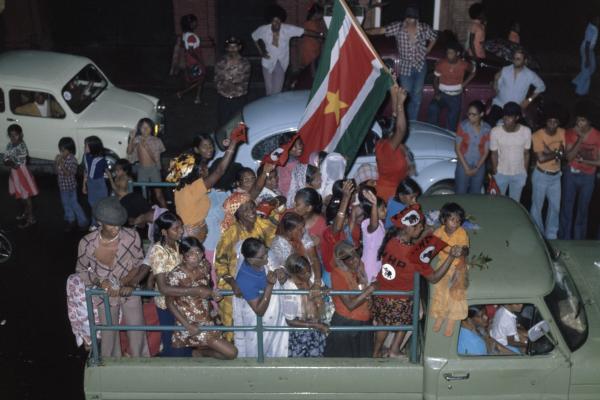 kleurenfoto onafhankelijkheid vierende Surinamers achterin pickup truck 1975 