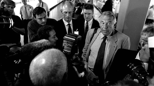 Van Mierlo terug uit Brazilie op Schiphol waar hij aan de pers uitlegt waarom Bouterse niet is aangehouden. 21-8-97