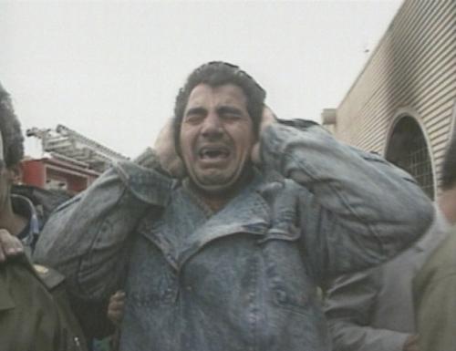 Een Irakese man staat huilend bij de resten van de gebombardeerde schuilkelder