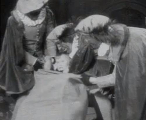 Jongetje wordt door Pieten in zak gestopt tijdens bezoek Sinterklaas aan concert voor kinderen van frontsoldaten (5 december 1941)