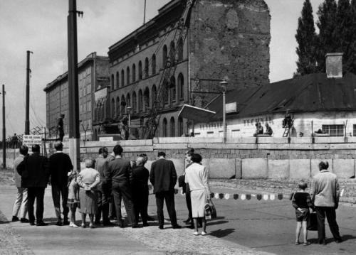 Een groepje mensen kijkt toe hoe de Muur versterkt wordt, 28 juli, 1962 (Landesarchiv Berlin, Gert Schütz, nr. 83487)